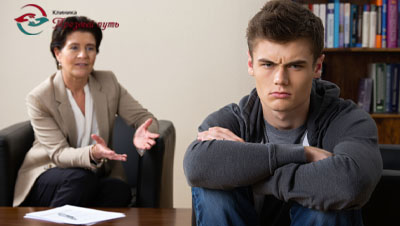 Подросток злится, сидит спиной к взрослому